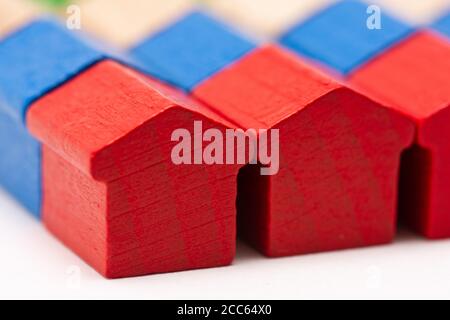 Reihen von kleinen Holzspielzeughäusern in verschiedenen Farben bemalt Stockfoto