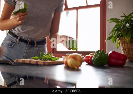 Junge Frau bereitet vegetarisches Abendessen in einer Küche Stockfoto