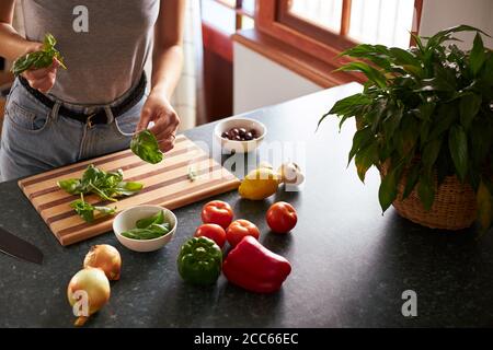 Junge Frau bereitet vegetarisches Abendessen in einer Küche Stockfoto