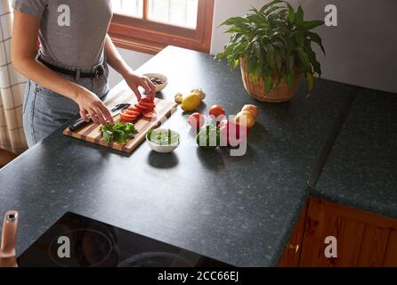 Junge Frau bereitet vegetarisches Abendessen in einer Küche Stockfoto