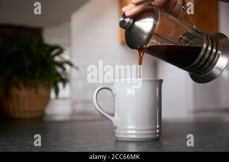 Zum Frühstück wird frischer Kaffee aus einer cafetiere gegossen. Stockfoto