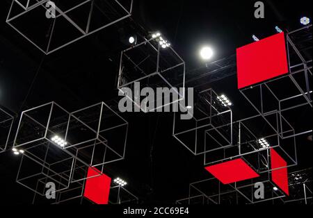 Metall-Würfel-Box mit dem LED-Bildschirm schwimmt an der Decke zur Dekoration in der Ausstellungshalle. Stockfoto