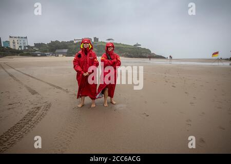 Tenby, Pembrokeshire, West Wales, Großbritannien. August 2020. Zwei RNLI-Rettungsschwimmer blicken auf das Meer und überwachen die Brandungswellen am Strand von Tenby, Pembrokeshire in West Wales. In der Nacht und am darauffolgenden Sommertag trafen Stürme und schlechtes Wetter Südengland und West Wales, Großbritannien.Mittwoch, 19. August 2020. Tenby, Pembrokeshire, West Wales, UK Kredit: Jeff Gilbert/Alamy Live News Stockfoto