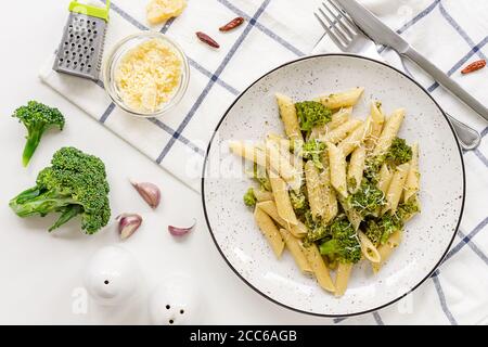 Pasta Penne mit Brokkoli und Parmesankäse auf weißem Tisch. Italienische Küche. Flach liegend. Stockfoto