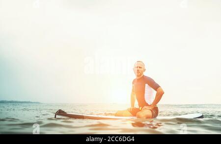 Man Surfer sitzt auf Surfbrett im Wasser und Wartet Kurven Stockfoto