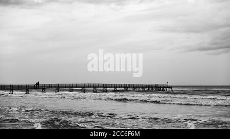 Panorama-Seesicht mit dem Meer und langen Pier. Schwarz-Weiß-Landschaft. Rimini in der Nebensaison, Italien Stockfoto