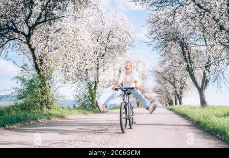 Mann haben Spaß, wenn ein Fahrrad auf Landstraße fährt Stockfoto