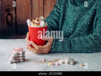 Weibliche Hände halten Tasse heiße Schokolade mit Marshmallow Stockfoto
