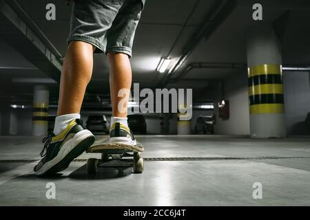 Junge auf Skateboard Schlittschuhe in undeground Parkplatz Nahaufnahme Bild Stockfoto