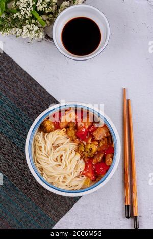 Gebratenes Huhn mit Nudeln in einer Schüssel umrühren. Draufsicht. Stockfoto