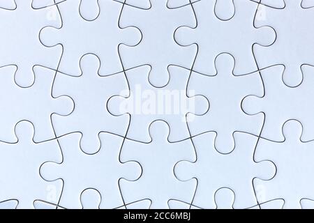 Weiße Puzzle-Stücke auf grauem Hintergrund Stockfoto