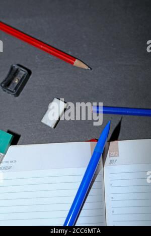 Zurück zur Schule. Gegenstände für die Schule auf schwarzen Holztischen. Stockfoto
