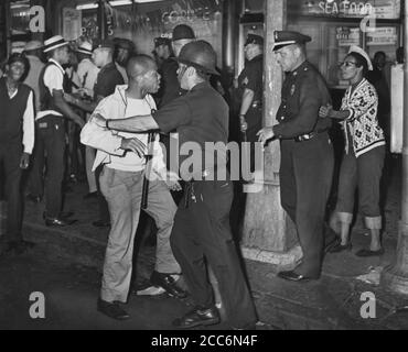 Polizisten konfrontieren eine Gruppe von Menschen nach nächtlicher Ausschreitungen wegen der tödlichen Erschießung von Teen James Powell durch den Polizeibeamten LT. Thomas Gilligan, Fulton St. und Nostrand Ave., Brooklyn, New York, USA, Stanley Wolfson, World Telegram & Sun, 21. Juli 1964 Stockfoto