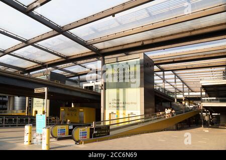 Reisende betreten den Nordterminal des Flughafens London Gatwick im Vereinigten Königreich. Sie fahren mit einem Förderband in den Abflugbereich. Stockfoto