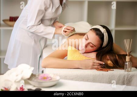 Frau genießt eine Salzpeeling-Massage im Wellness-Center Stockfoto
