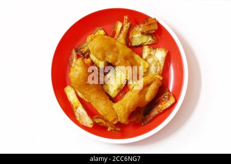 Südindischer Kartoffel-Snack, Vazhakkai Bajji serviert in einem roten Teller auf weißem Hintergrund Stockfoto