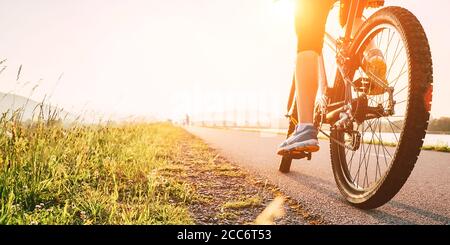 Frau Füße auf bycikle Pedal in Sonnenuntergang Licht Stockfoto