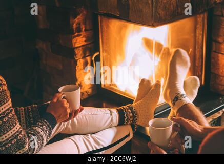 A couple in love drink tea near the fireplace. Cozy Christmas home atmosphere Stockfoto