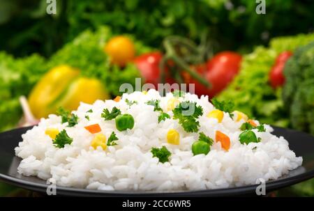 Gekochter Reisbrei, serviert mit Kräutern und Gemüse Stockfoto