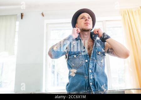 Tänzer in Jeansjacke posiert in Tanzhalle Stockfoto