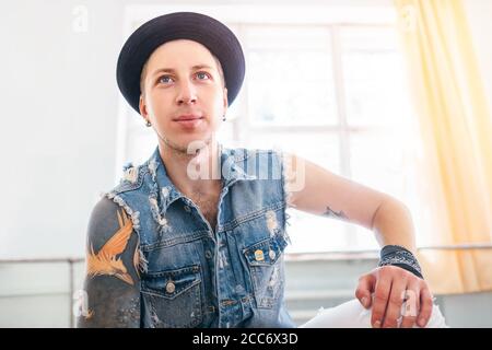Tänzer junger Mann in Jeansjacke posiert in Tanzsaal Stockfoto