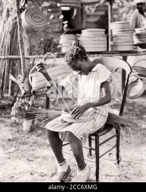 1930ER JAHRE ANONYMOUS LÄCHELND JUNGE AFROAMERIKANISCHE GULLAH-MÄDCHEN WEBEREI KORB VON SWEETGRASS SOUTH CAROLINA USA - N1204 HAR001 HARS NOSTALGIE ALTE MODE 1 JUGENDLICHE KARRIERE LIFESTYLE FEIER FRAUEN JOBS RURAL HEALTHINESS HOME LIFE VEREINIGTE STAATEN KOPIEREN RAUM VOLLER LÄNGE HIGHWAY PERSONEN INSPIRATION TRADITIONELLE VEREINIGTE STAATEN VON AMERIKA TEENAGER-MÄDCHEN BERUF HANDWERK SPIRITUALITÄT VERTRAUEN B&W TRAURIGKEIT NORDAMERIKA NORDAMERIKA NORDAMERIKA GEORGIEN SKILL BERUF GLÜCK FÄHIGKEITEN SPRACHE WELLNESS STÄRKE KUNDENSERVICE AFROAMERIKANER AFROAMERIKANISCHE KARRIEREN WISSEN TOURISMUS Stockfoto