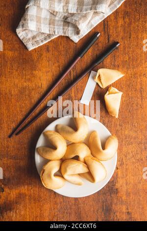 Chinesische Glücksplätzchen. Glückskekse auf Teller und Essstäbchen. Draufsicht. Stockfoto