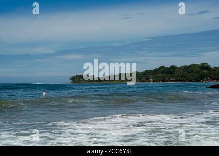 Surfer am Meer, türkisfarbenes Wasser, blauer Himmel. Arugam Bay, Sri Lanka. Hochformat Stockfoto