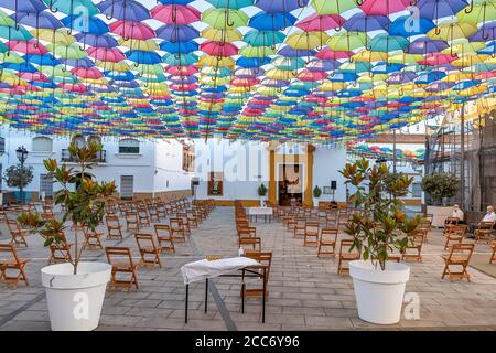 Huelva, Spanien - 15. August 2020; der Platz vor der Kirche ist für eine Messe in der Straße mit Sonnenschirmen in den Himmel im Dorf San B vorbereitet Stockfoto