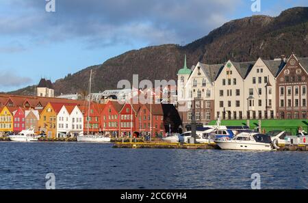 Bergen, Norwegen - 19. November 2017: Küstenstadtbild mit traditionellen norwegischen Häusern. Gewöhnliche Menschen gehen die Straße entlang. Bergen Bryggen Stockfoto