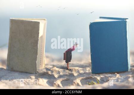 Surrealer Moment einer kleinen Frau, die vom Snooping träumt In den Seiten der riesigen Bücher Stockfoto