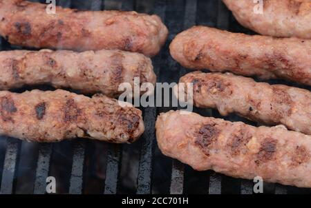 Cevapi auf dem Grill. Traditionelle balkanische Küche - delicius Hackfleisch. Mici, Mititei, kleine rumänische Hackfleischröllchen, ähnlich serbischer Cevapi, frisch b Stockfoto