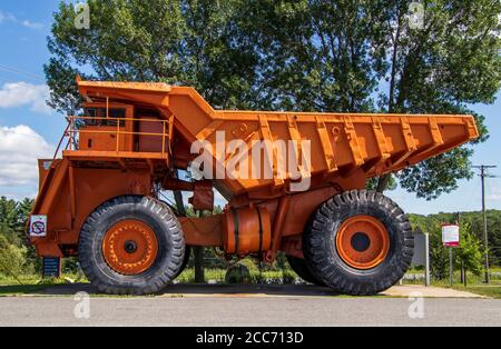 15. August 2020 - Asbest, Québec, Kanada: Riesiger Orange Mine Truck in Asbeststadt in der Nähe von geschlossener Mine geparkt Stockfoto