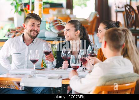 Freunde trinken Wein auf der Terrasse des Restaurants Stockfoto