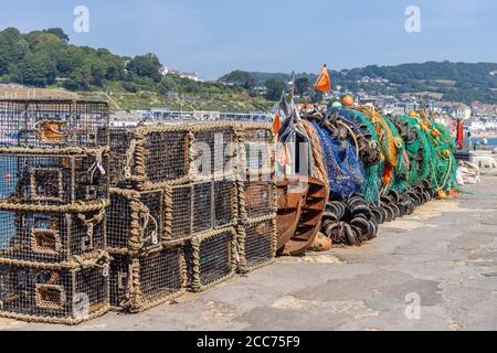 Hummertöpfe und Fischernetze auf dem Cobb bei Lyme Regis, einem beliebten Badeort an der Jurassic Coast in Dorset, SW England gestapelt Stockfoto