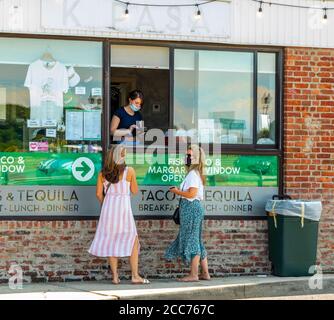 Zwei maskierte Frauen, die im K Pasa in Sag Harbor, NY, Lebensmittel bestellen Stockfoto
