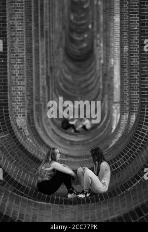 Junge Leute unter dem Ouse Valley Viaduct (Balcombe Viaduct) mit der London to Brighton Railway Line über den River Ouse in Sussex, Großbritannien Stockfoto