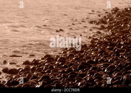 Steine am Strand bei Sonnenuntergang. Stockfoto