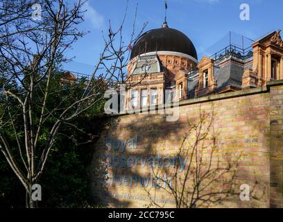 London, Großbritannien - 02. Februar 2019: Royal Observatory Greenwich Building Dome (gegründet 1675) mit Schild in der Nähe des Eingangs am sonnigen Frühlingstag. Stockfoto