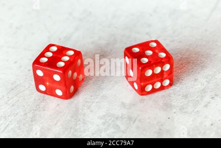 Zwei durchscheinende rote Würfelwürfelwürfelwürfelchen auf weißem Brett, das Yo zeigt (Yo-leven) (Nummer 6 und 5) Stockfoto