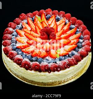 Einrichtung mit Obstkuchen mit verschiedenen Beeren und schwarzem Hintergrund Stockfoto