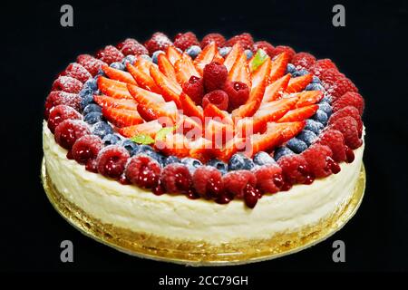 Käsekuchen mit verschiedenen frischen Beeren gemischt isoliert Stockfoto