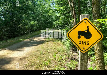 Lustiges Schild, das eine Traktorüberfahrt bezeichnet. Konzepte könnten Landwirtschaft, Landleben, Humor, andere umfassen. Stockfoto