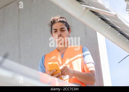 Junger männlicher Ingenieur mit Gerät, das draußen arbeitet Stockfoto