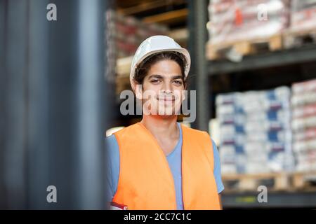 Junger Ladenarbeiter mit Helm, der in einem Geschäft arbeitet Stockfoto