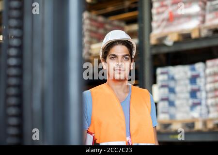 Junger Ladenarbeiter mit Helm, der in einem Geschäft arbeitet Stockfoto