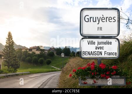 Gruyeres Zeichen am Eingang der Stadt und mittelalterlichen Dorf im Hintergrund in Gruyeres Schweiz ( Übersetzung : twinned mit Renaison Frankreich ) Stockfoto