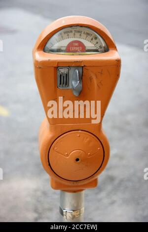 Ein alter, orangefarbener Parkuhr mit Graffiti. Stockfoto