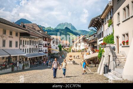 Gruyeres Schweiz , 27 Juni 2020 : Hauptpflasterstraße von Gruyeres mittelalterliches Dorf mit Touristen im Sommer 2020 in La Gruyere Fribourg SW Stockfoto
