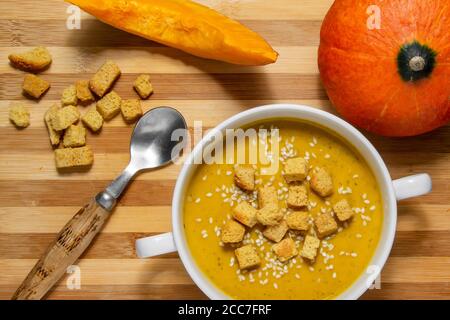 Herbstsuppe mit Sesamsamen auf Holzgrund. Herbstsuppe mit Sesamsamen auf Holzgrund. Kürbissuppe für richtige Nu Stockfoto